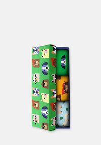 Conjunto de cuatro calcetines en una caja decorativa con un diseño verde que presenta varias cabezas de animales de dibujos animados. Los colores incluyen verde, amarillo y azul.