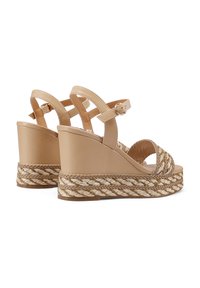 Sandali con zeppa beige con dettaglio in juta intrecciata e tomaia in pelle liscia. Fascetta alla caviglia regolabile e design aperto per una migliore ventilazione.