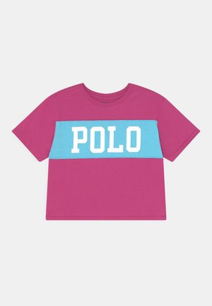 Magenta t-shirt met korte mouwen en een horizontale lichtblauwe streep over de borst waarop het woord "POLO" staat in vetgedrukte witte letters.