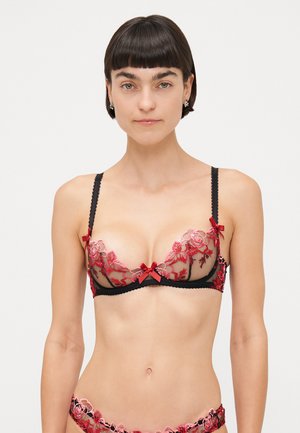 Reggiseno in pizzo nero con ricami floreali rossi e fiocchi. Design trasparente con dettagli intricati, spalline regolabili e bordi a scallop.