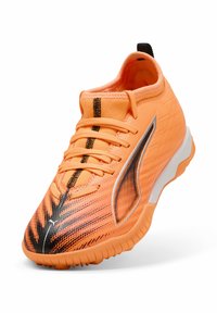 Scarpa da ginnastica di un arancione brillante con superficie testurizzata, dettagli neri e colletto imbottito. Presenta suola in gomma e lacci regolabili.