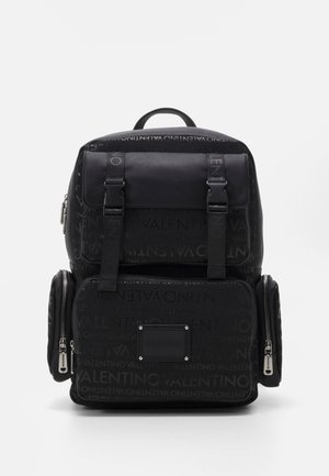 Zwarte Valentino rugzak met meerdere ritstassen, voorsluiting beveiligd door twee riemen en een geperst logopatroon op de stof.
