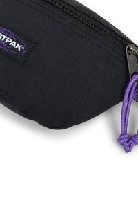 Czarny piórnik na zamek wykonany z teksturowanej tkaniny, z fioletowym sznurkiem przy zamku i metką z logo w kształcie globu.