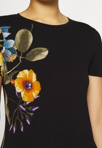 Czarna koszulka z krótkim rękawem z kolorowymi nadrukami kwiatowymi w odcieniach pomarańczowym, niebieskim i zielonym. Miękka tkanina, okrągły dekolt i dopasowany krój.