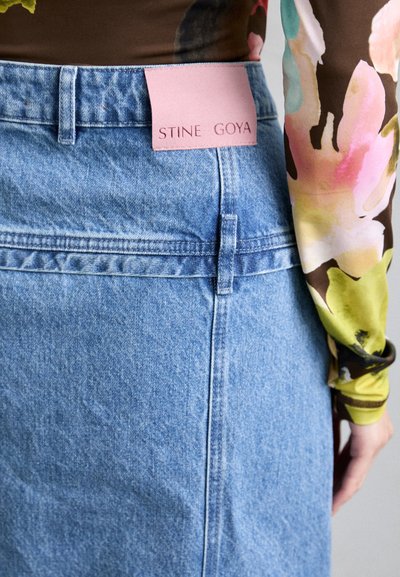 Τζιν φούστα σε ανοιχτό μπλε, με ραμμένο ζωνάκι και λογότυπο σε ροζ. Λείος υφασμάτινος σχεδιασμός με fitted γραμμή και λεπτομέρεια πίσω ραφής.