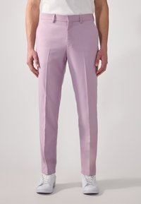 Lilas dressbukser med en glatt tekstur, skreddersydd passform og sidelister. Brukt med hvite sneakers for en uformell stil.