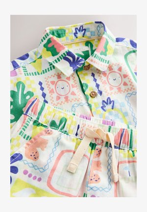 Spalvingas medvilninis komplektas, kuriame yra marškiniai su apykakle ir sagomis bei raštuoti šortai, puošiami žaismingais paveiksliukais ir su elastiniu liemeniu.