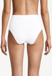 Witte hoogsluitende onderbroek met een gladde textuur, elastische tailleband en ontwerp met volledige bedekking, zichtbaar vanuit de achterkant tegen een neutrale achtergrond.