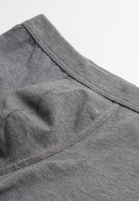 Graues, weiches Textilkleidungsstück mit glatter Textur, das einen einfachen Rundhalsausschnitt und dezente Steppnähte aufweist, schräg gefaltet.