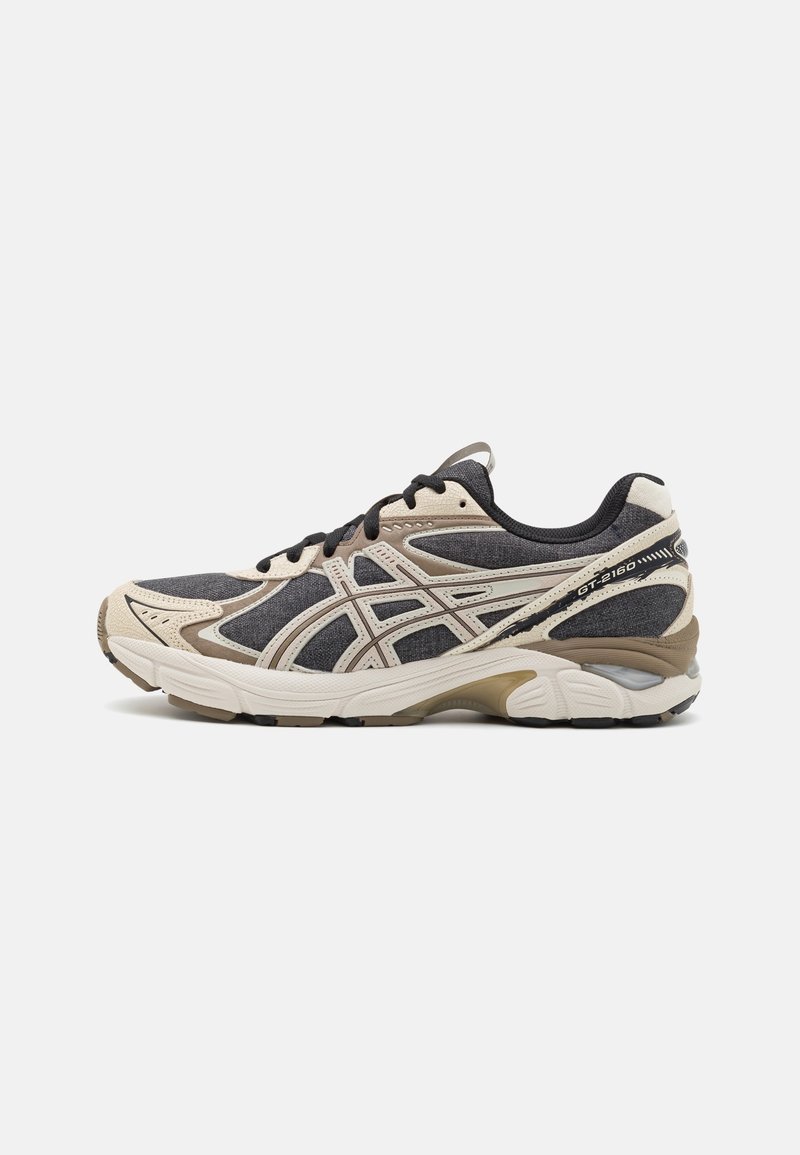 Black and beige athletic shoes with mesh and synthetic upper, featuring a curved sole, contrasting accents, and a lace-up design.