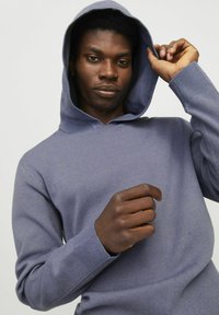 Kapuzensweater aus einem weichen, helllila Stoff. Verfügt über gerippte Bündchen und Saum, mit einer strukturierten Webart und einer lässigen Passform.