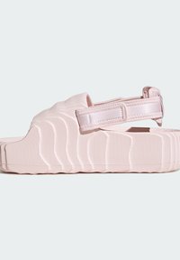 Svetloružové sandále s žebrovanou textúrou, nastaviteľným popruhom a hrubou, polstrovanou podrážkou. Majú zvlnený dizajn po celom vršku.