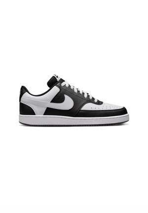 Low-top sorte og hvide Nike sneakers med hvide snørebånd, perforeret tåboks og klassisk swoosh-logo på siden.