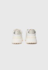 Sneaker bianche con tomaia in pelle liscia, forma arrotondata e suola spessa. Presentano dettagli metallici e design con lacci. Motivo del battistrada testurizzato.
