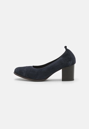 Escarpin en daim bleu marine à talon haut avec un bout rond et un talon bloc texturé, présenté sur un fond blanc uni.