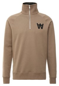 Beżowa bluza z zamkiem przy szyi, o fakturowanym wykończeniu, z prążkowanymi mankietami i dołem, z czarnym logo na piersi. Gładka tkanina, luźny krój.