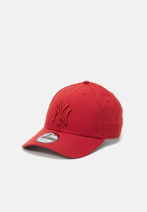Casquette de baseball rouge avec une visière courbée, logo brodé en rouge assorti, design structuré et trous d'aération en œillet.