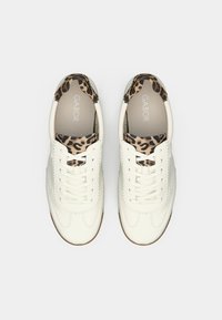 Λευκά δερμάτινα αθλητικά παπούτσια με επένδυση λεοπάρ γύρω από τον αστράγαλο, με σχέδιο κορδονιών, στρογγυλή μύτη και καουτσούκ σόλα.