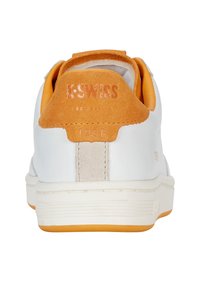K-Swiss sportcipő, fehér bőr felsőrésszel, narancssárga velúr sarokpanellel, krémszínű középtalppal és gumitalppal. Texturált részletek a sarokon.