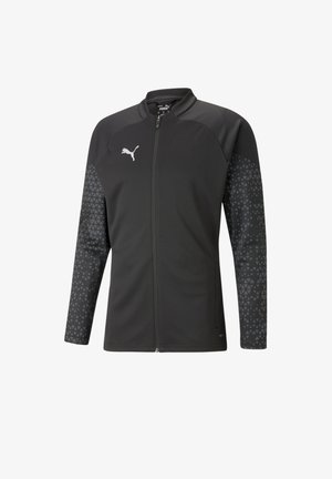 Schwarze Zip-Jacke aus strukturiertem Stoff, mit einem geometrischen Muster auf den Ärmeln und einem kleinen weißen Logo auf der Brust.