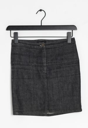 Jupe en denim gris foncé, avec une coupe ajustée, des poches avant et un détail de couture horizontal près de la taille. Suspendue à un crochet noir.