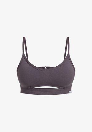 Brassière de sport grise avec des bretelles fines, une texture côtelée et un détail de découpe horizontal au centre avant. Design sans couture pour le confort.