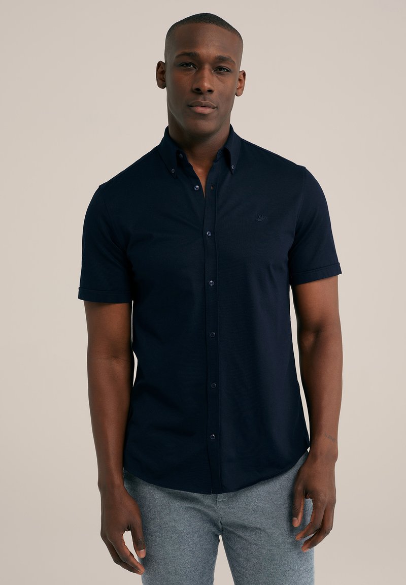 Cămașă button-up cu mânecă scurtă de culoare albastru marin, cu o croială slim, având un logo brodat subtil pe piept și o textură netedă din bumbac.