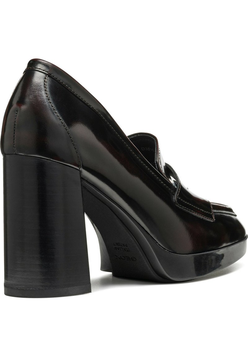 Scarpa con tacco alto in pelle verniciata nera, con tacco spesso a blocco, punta rotonda e cuciture decorative sulla tomaia. Texture liscia e lucida.
