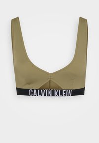 Olijfgroene bralette van soepel materiaal, met een brede zwarte elastieken band met het witte "CALVIN KLEIN" logo en een uitsnijding aan de achterkant.