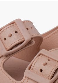 Sandalias sintéticas rosas con dos correas anchas, hebillas ajustables y perforaciones. Parte superior texturizada y forro interior suave.