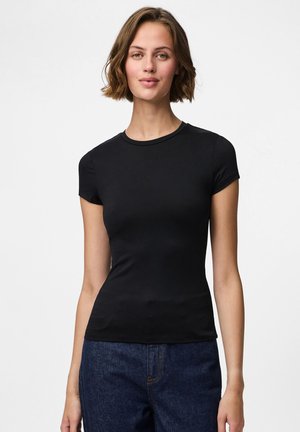 Sort kortærmet t-shirt lavet af blødt, strækbart materiale. Tætsiddende design med rund halsudskæring, parret med løse denimjeans.