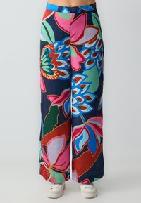 Kleurvolle wijde broek met een bloemenpatroon op een donkere achtergrond, gemaakt van lichte stof met een gladde textuur.