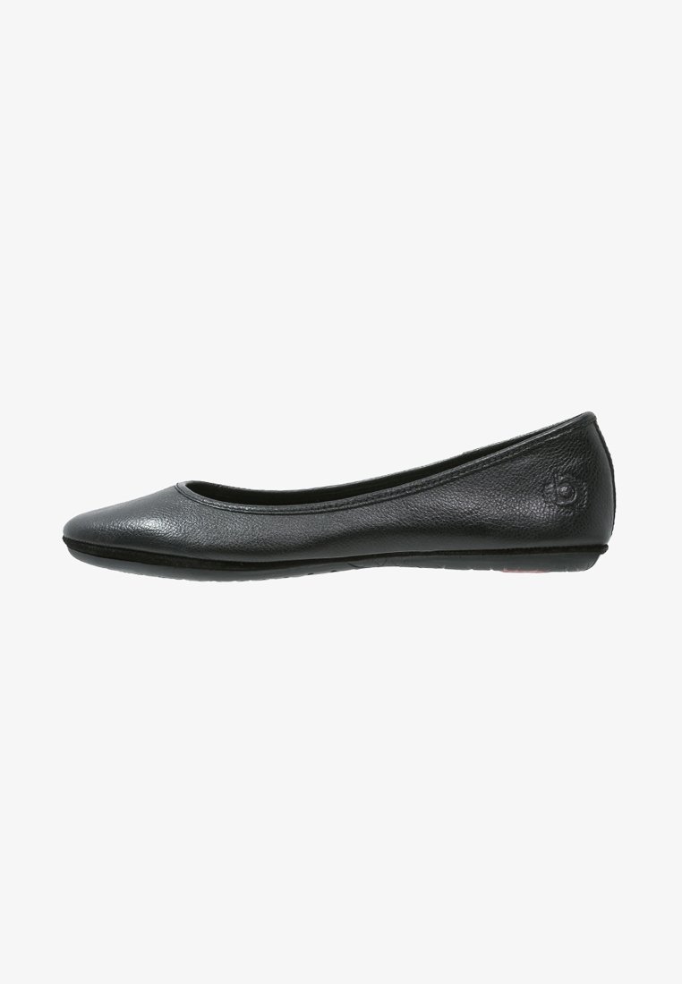 Chaussure de ballet plate en cuir noir avec bout arrondi et petit logo embossé sur le talon, vue de côté sur fond blanc.