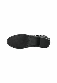 Suela de zapato de vestir de cuero negro con patrón de agarre texturizado y tacón bajo apilado, tamaño marcado 37, fotografiada desde abajo.