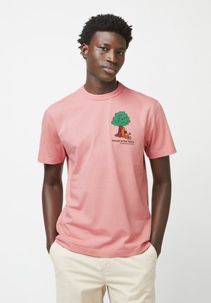 Roze katoenen t-shirt met een grafische afbeelding van een groene boom met een karakter. Korte mouwen en een ronde halslijn. Zachte textuur.