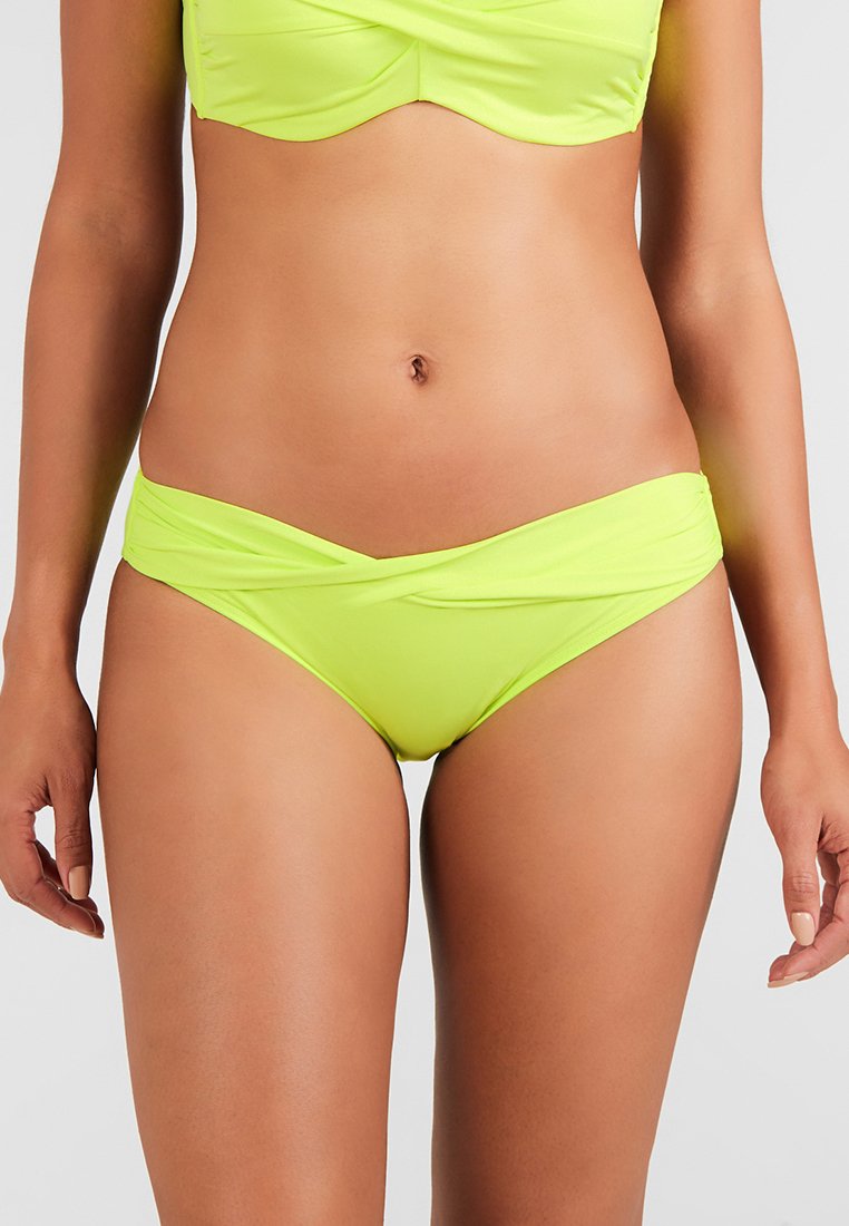 Bikini verde neón con un top halter ajustado y braguitas de cintura alta con detalles retorcidos. Material suave y elástico con costuras mínimas.