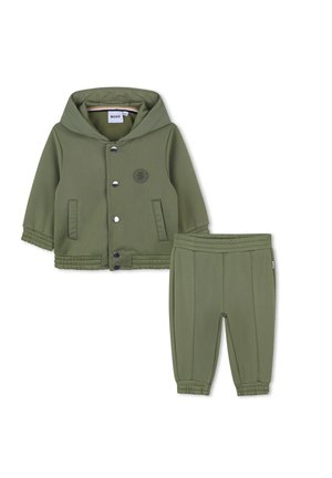 Ensemble deux pièces vert olive comprenant une veste à capuche avec boutons-pression et un pantalon ajusté assorti avec une taille élastique.