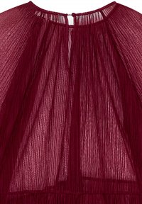 Blusa plissettata bordeaux realizzata in tessuto trasparente, con collo alto, chiusura a chiave sul retro e design fluido e testurizzato.