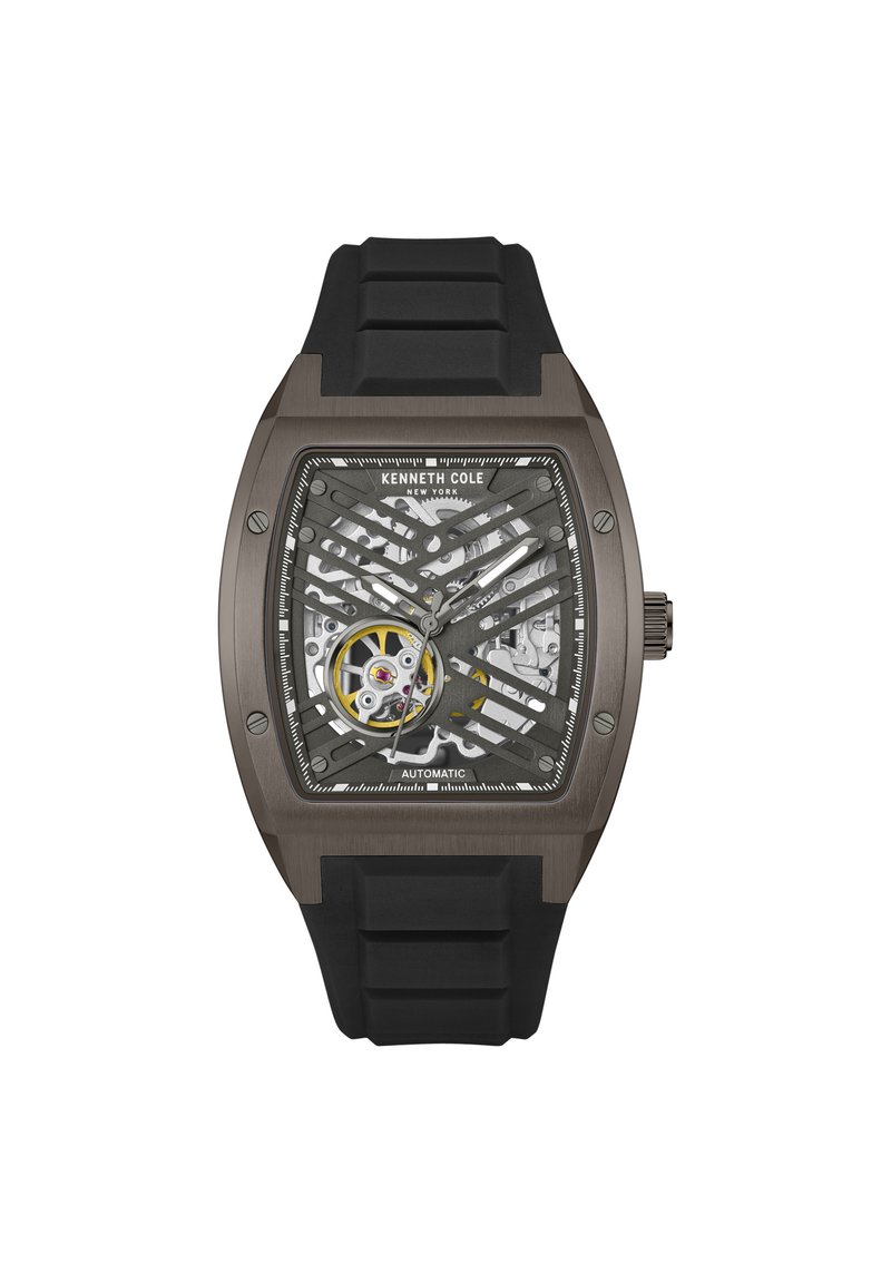 Kenneth Cole automatski sat ima prozirni skeleton brojčanik, crnu silikonsku narukvicu i pravokutno sivo kućište s mrežastim detaljima.