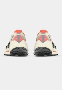 Mustavalkoiset juoksukengät, joissa on teksturoitu päällinen, kirkkaan oranssit yksityiskohdat, pehmustettu pohja ja kestävä urasommittelu pidon takaamiseksi.