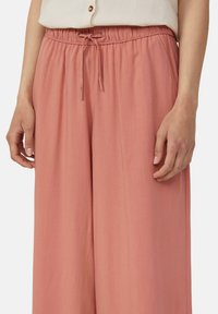 Lichte, loszittende broek in een zachte blushkleur, met een elastische tailleband met een trekkoord en zijzakken.