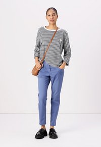 Black and white striped long-sleeve top, light blue tapered pants, black platform shoes, and brown crossbody bag. Simple, casual ensemble.