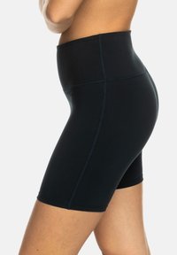 Høyt liv svarte shorts laget av stretchy materiale, med en glatt tekstur og kontrastsømmer, designet for komfort og fleksibilitet.