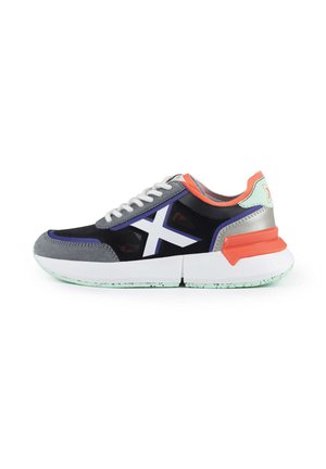 Baskets avec une tige en mesh noir et des accents en daim gris, des lacets blancs et une semelle intermédiaire chunky blanche avec des détails orange et menthe.