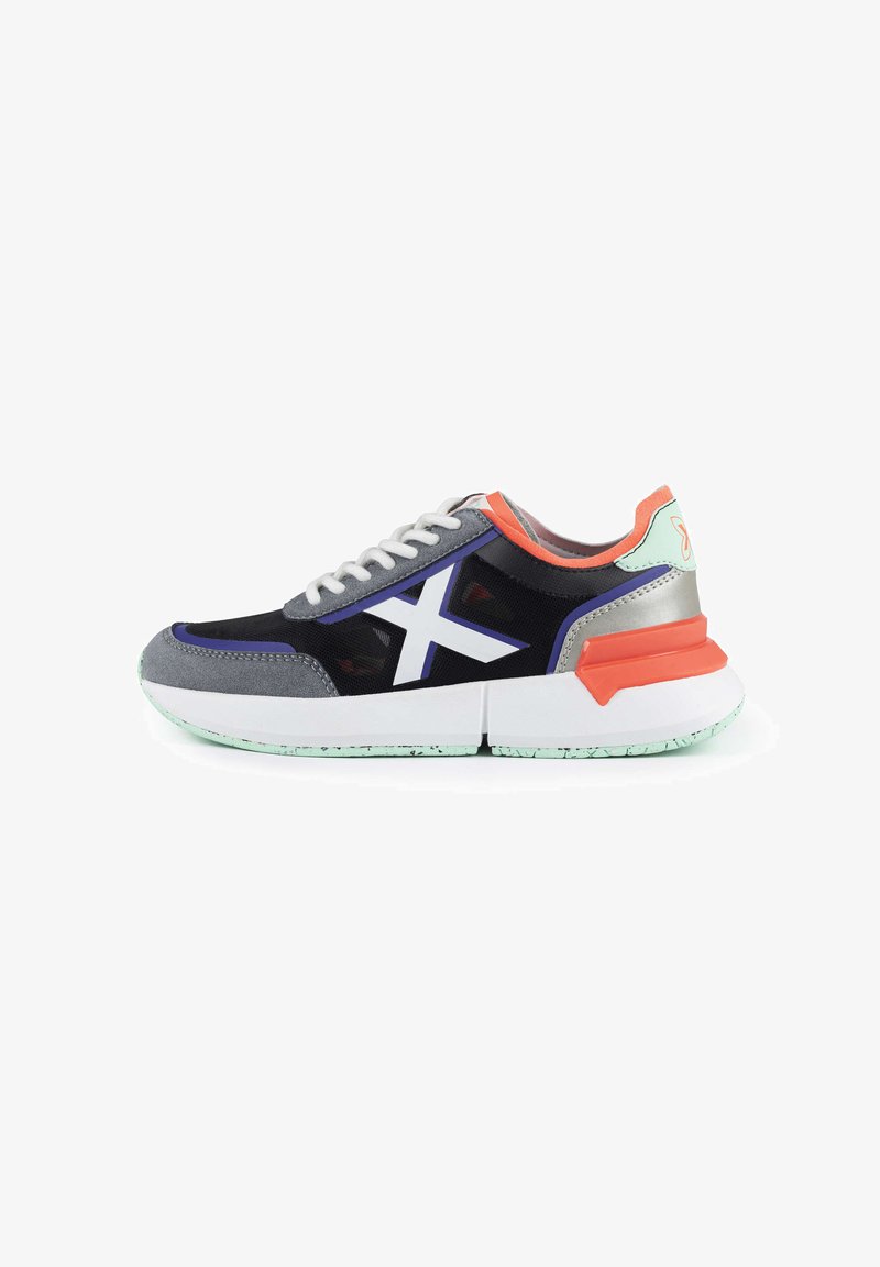Sneakers z czarną siateczkową cholewką z szarymi zamszowymi akcentami, białymi sznurowadłami oraz masywną białą podeszwą środkową z pomarańczowymi i miętowymi detalami.