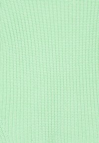 Helles grün gestricktes Gewebe mit einem strukturierten Rippenmuster, das durch gleichmäßig verteilte, vertikale Rillen im gesamten Stoff gekennzeichnet ist.