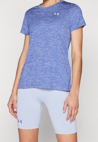 Blå ljung t-shirt med kort ärm, gjord av fukttransporterande tyg, tillsammans med ljusblå passande shorts med en logotyp.