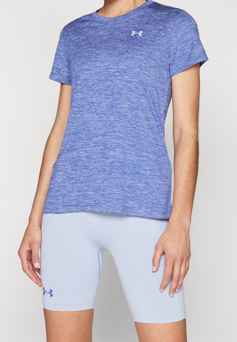 Blå ljung t-shirt med kort ärm, gjord av fukttransporterande tyg, tillsammans med ljusblå passande shorts med en logotyp.