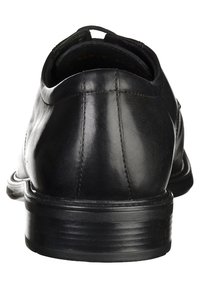Scarpa nera in pelle con una texture liscia, forma arrotondata e tacco basso. Il retro presenta cuciture sottili e un design minimalista.