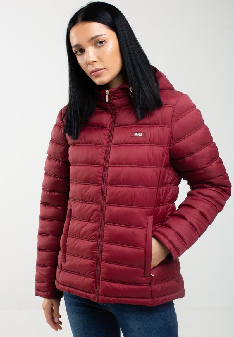 Bordo mīksts mētelis ar rāvējslēdzēju priekšpusē, kapuci un sānu kabatām. Iezīmes - quilted dizains un mazs logo uz krūtīm. Gluda tekstūra.